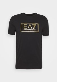 Svart bomullströja med ett guldtryckt rektangulärt logotyp som läser "EA7 EMPORIO ARMANI" på framsidan. Rund hals, korta ärmar.