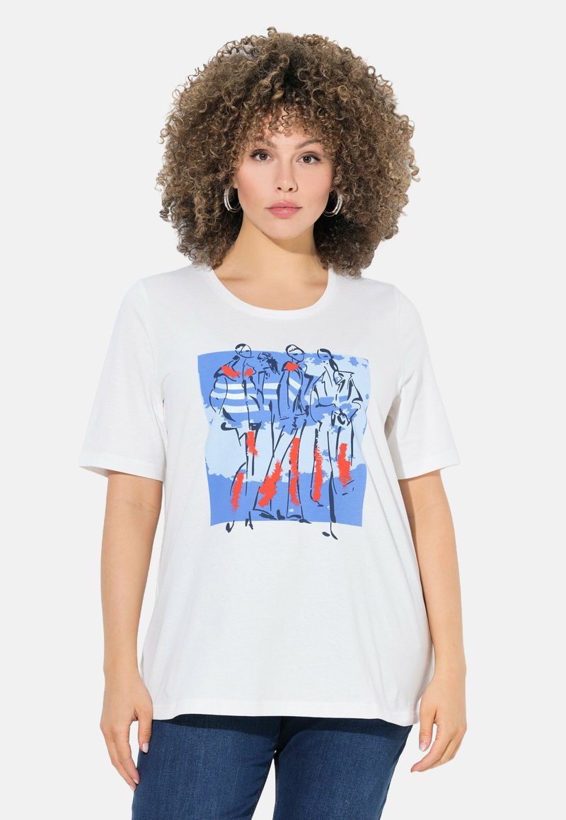 T-shirt blanc à manches courtes avec une illustration graphique en bleu et rouge de figures sur un fond bleu ; tissu en coton doux.