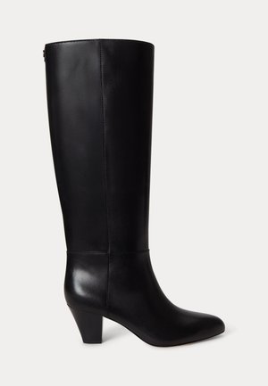 Botte haute en cuir noir avec bout arrondi et talon bloc de hauteur moyenne sur fond blanc.