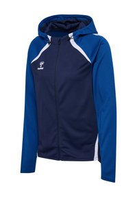 Marineblauwe capuchonjack met witte accenten, ritssluiting en lange mouwen, gemaakt van gestructureerde stof die geschikt is voor actieve kleding.