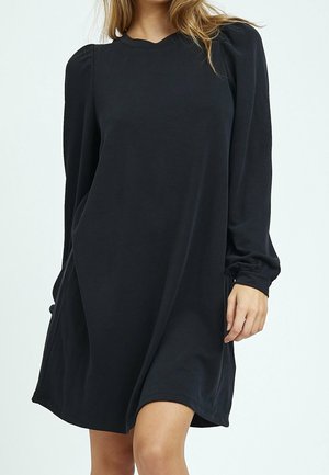 Robe noire à manches longues avec une coupe décontractée, un col rond et des épaules froncées. Tissu doux et lisse avec un léger éclat.