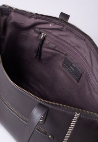 Dark brown leather tote bag with a zipper closure, featuring a fabric-lined interior and an internal zippered pocket.