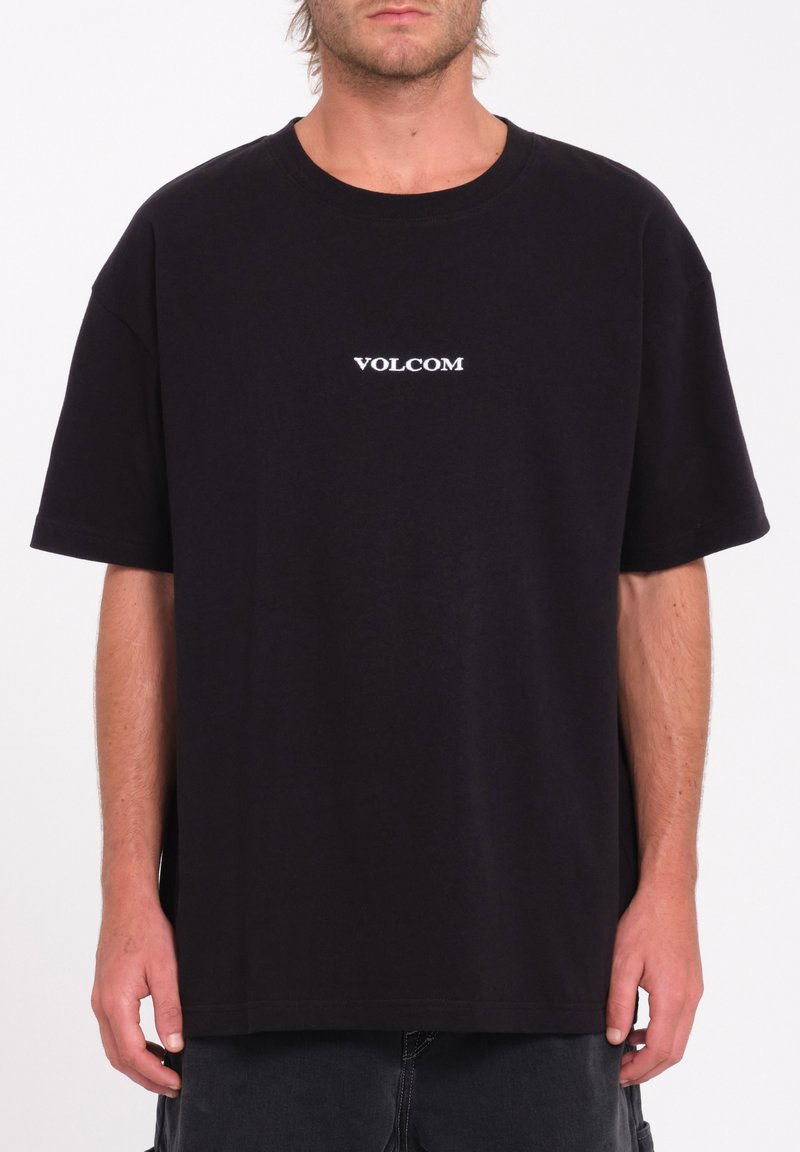 Black cotton t-shirt featuring a white "VOLCOM" logo on the chest, short sleeves, and a relaxed fit with a straight hem.