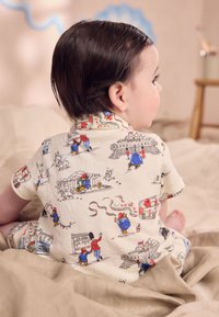 Īsām piedurknēm, krēmkrāsas toddler krekls ar krāsainām ilustrācijām, attēlojot dzīvniekus un cilvēkus dažādās ainās, ar apkakles dizainu.