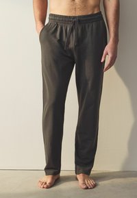 Pantaloni de lounge din bumbac gri închis, cu croi lejer, talie elastică și șnur, având buzunare laterale și picioare taperate.