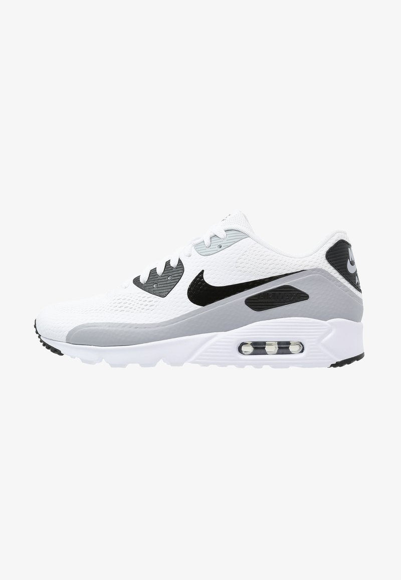 Baskets Nike Air Max blanches et grises avec logo swoosh noir, coussin d’air visible dans la semelle et lacets blancs sur fond blanc.