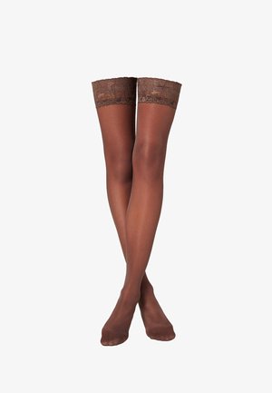 Braune, oberschenkelhohe, transparente Strümpfe mit Spitzenrand, getragen an übereinandergeschlagenen Beinen vor weißem Hintergrund.