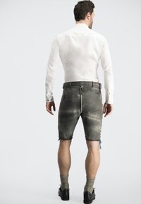 Graue Shorts mit leicht abgewetzter Textur, ausgestattet mit einem Kordelzugbund und Seitentaschen, kombiniert mit einem weißen Langarmshirt.