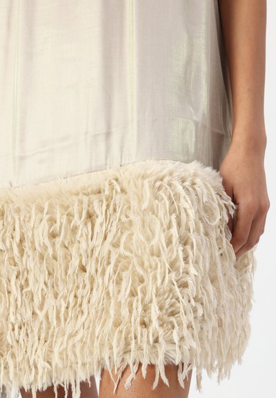 Robe jusqu'au genou avec un haut lisse gris clair et un ourlet crémeux moelleux et texturé, fait de longues fibres douces.