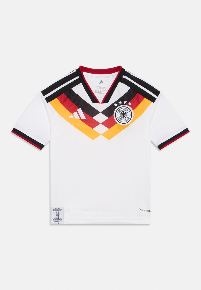 Camisola desportiva branca com detalhes em preto e vermelho, apresentando um design de gola em V, padrão de diamante em preto, vermelho e amarelo, e um emblema no peito.