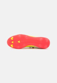 Crampon de fotbal cu o talpă roz aprins și galben, având un grip texturat și cu cuie modelate pentru tracțiune pe suprafețele de iarbă.