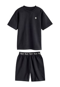 T-shirt nera a maniche corte con piccolo logo teschio e pantaloncini neri abbinati con vita elastica con motivo di testo "Next".
