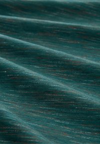Texturovaná tkanina v tmavě tyrkysové barvě s jemnými oranžovými a bílými pruhy, s měkkým, hladkým povrchem, který se elegantně splývá.