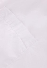 Weißer Stoff mit glatter Textur und sichtbaren Nähten. Das Material wirkt leicht und hat einen dezenten Glanz.