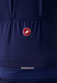 Námornícky atletický top s rebrovanou textúrou, priliehajúcim strihom, elastickým spodným okrajom a červeným kruhovým logom so symbolem škorpióna v strede.