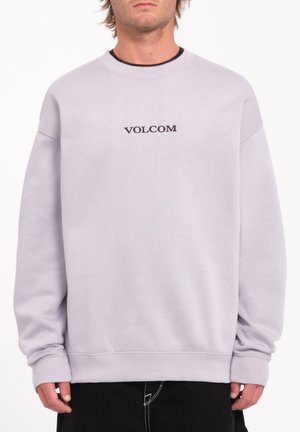 Sudadera de color gris claro con cuello redondo y corte holgado. Logo "VOLCOM" exhibido en negro en el centro. Puños y dobladillo acanalados.
