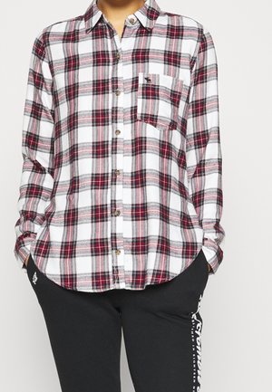 Camicia in flanella a quadri bianca, rossa e grigia. Presenta chiusura con bottoni, colletto e taschino sul petto. Tessuto morbido con vestibilità comoda.