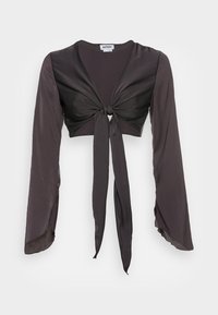 Blouse noire cropped avec de longues manches fluides, dotée d'une fermeture à nouer à l'avant et d'une texture lisse semblable à de la satin.