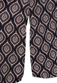 Schwarzer Stoff mit weißem geometrischem Muster, das blattförmige Designs zeigt, die in Braun umrandet sind. Strukturierten Oberfläche mit faltiger Optik.