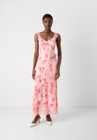 Pink floral maxi dress with ruffle details, fitted bodice, and spaghetti straps. Lightweight fabric drapes elegantly to the floor.