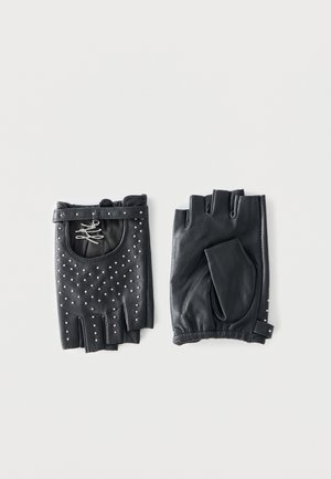 Par de guantes de cuero negros sin dedos, uno adornado con pequeñas cuentas plateadas, el otro liso, colocados planos sobre un fondo claro.