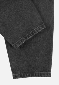 Czarne dżinsy z denimu o gładkiej fakturze, prostym kroju nogawki oraz subtelnym przeszyciu wzdłuż dołu. Materiał wydaje się solidny i trwały.