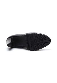 Zapato de cuero negro con punta redonda y suela de goma texturizada. Presenta un tacón bajo y un diseño sin cordones para facilitar su uso.