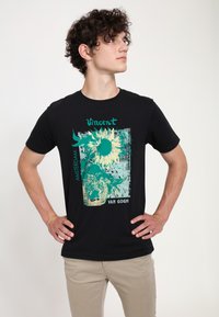 Camiseta de algodón negra con un gráfico de girasol de Van Gogh en turquesa y amarillo, con acentos de texto que dicen "Vincent", "Amsterdam" y "Van Gogh".