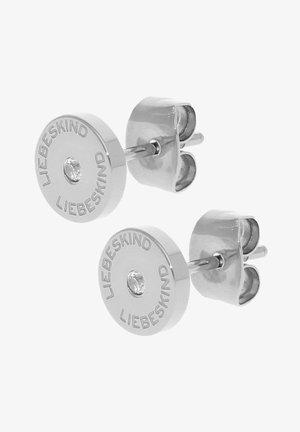 Silverfärgade studs med ett cirkulärt mönster, prydda med ingraverad text "LIEBESKIND" och en central klar sten. Högpolerad yta.