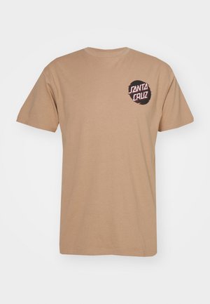 Beige T-shirt met korte mouwen en een klein zwart cirkellogo met de tekst "Santa Cruz" in wit en rood op het linkerborstgebied.