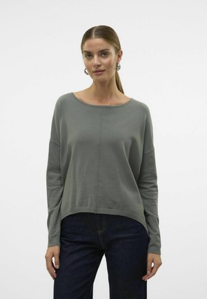 Lys grå langermet genser med bred utrigning, løs passform, ribbestrikket nederkant og rett snitt, kombinert med mørke denimjeans.