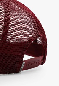 Gorra snapback de malla roja con frente estructurado, correa de plástico ajustable y etiqueta de marca en el lado. Presenta un diseño transpirable.