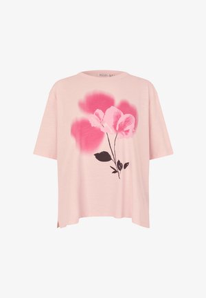 T-shirt oversize rose clair en tissu doux, avec un motif graphique de fleurs roses et de feuilles noires sur le devant.