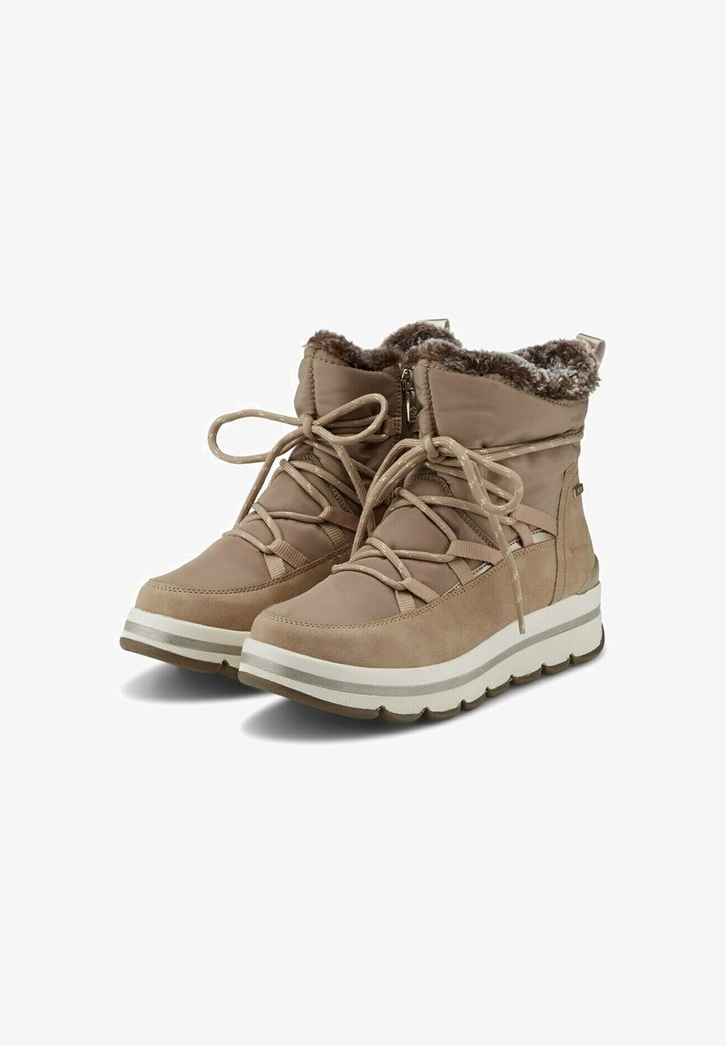 Beige enkelboots met een zachte voering van bont, bovenwerk van suède en stof, vetersluiting aan de voorkant, en een witte foam zool met een subtiele gestreepte accentering.