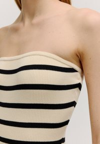 Beige strapless top met zwarte horizontale strepen, gemaakt van ribgebreide stof met een gladde textuur en een aansluitend ontwerp.
