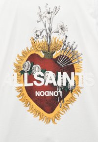White shirt featuring a graphic of a red heart with yellow flames, roses, swords, and floral accents. Text reads "ALLSAINTS LONDON."