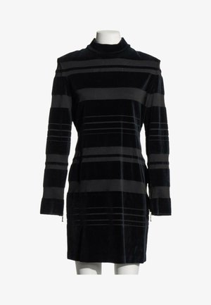 Mini-robe noire à manches longues avec des rayures horizontales grises et un col haut, présentée sur un buste de mannequin blanc.