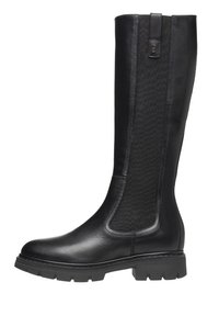 Botas negras hasta la rodilla con exterior de cuero liso y paneles textiles. La suela es gruesa con un patrón de dibujo para mayor agarre.