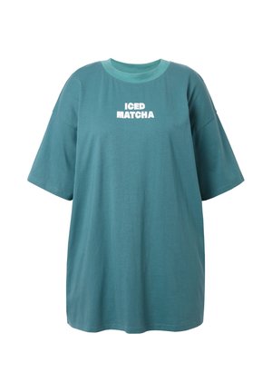 Turquoise oversized T-shirt van katoen, met korte mouwen en de tekst "ICED MATCHA" in het wit over de borst.