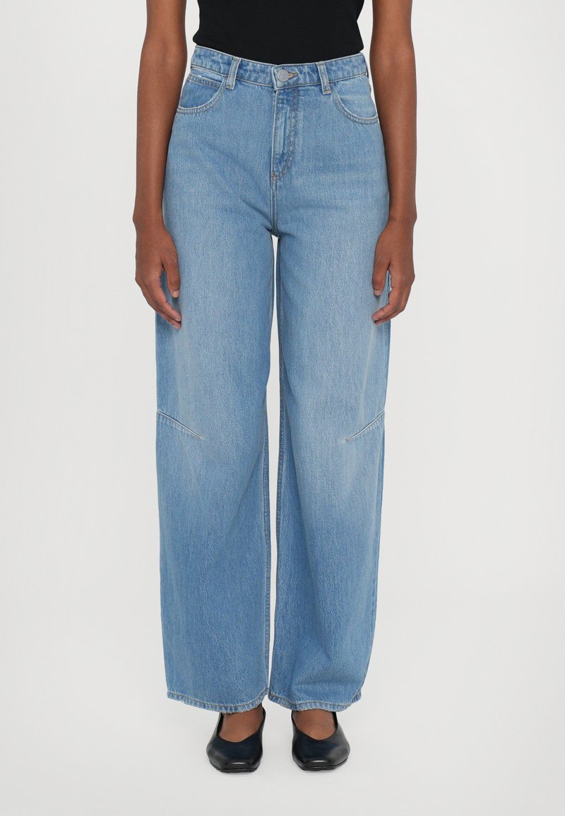 Hellblaue weit geschnittene Jeans aus Denim, mit hoher Taille, großen Taschen und subtilen Steppdetails.
