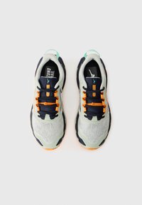 Scarpe da corsa grigio chiaro con accenti blu navy, lacci arancioni, parte superiore testurizzata e suola flessibile. Presenta un tassello sul tallone verde e dettagli del logo.