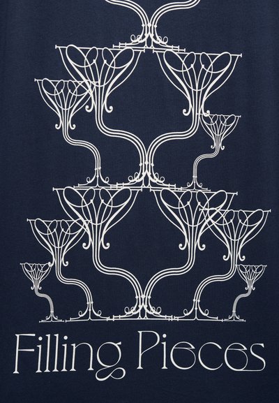 Υφασμα σε ναυτικό μπλε με περίπλοκα λευκά σχέδια από γραμμές που μοιάζουν με αφηρημένα φυτά, με το κείμενο «Filling Pieces» στο κάτω μέρος.
