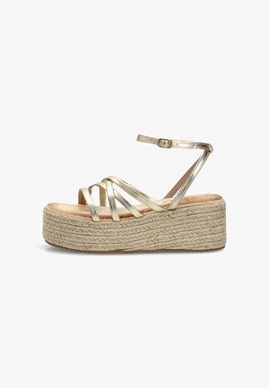 Sandalia cuña de plataforma beige con tiras metálicas doradas entrecruzadas y hebilla en el tobillo, suela de cuerda trenzada y plantilla acolchada.