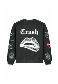 Felpa nera con una grande grafica di labbra bianche, testo "Crush" e diverse toppe multicolori sulle maniche. Il testo e i disegni variano nello stile.
