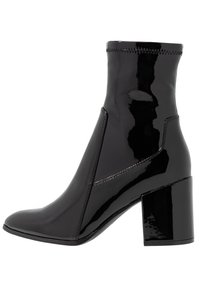 Botas negras de charol hasta el tobillo con punta afilada, tacón cuadrado y paneles laterales elásticos. Presentan costura decorativa a lo largo del borde superior.