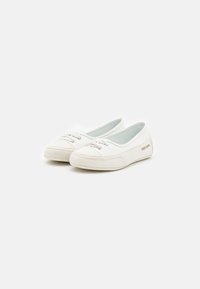 Des chaussures en toile blanches présentent une pointe ronde, un laçage à l'avant avec des œillets métalliques, une doublure intérieure douce et un subtil logo sur le côté.
