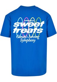 Blå bomulds t-shirt med et stort hvidt grafisk motiv, der står "sweet treats" og "Candy's Loving Symphony", med farverige accentlinjer.