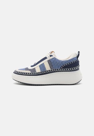 Niskoprofilowy sneaker z niebiesko-białą tkana cholewką, grubą białą podeszwą i kontrastującymi przeszyciami wzdłuż krawędzi.