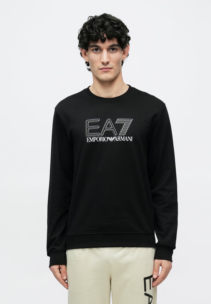 Fekete, hosszú ujjú pulóver kerek nyakkal, fehér EA7 és Emporio Armani logókkal. Az anyag simának tűnik; bordázott mandzsetták és szegély.