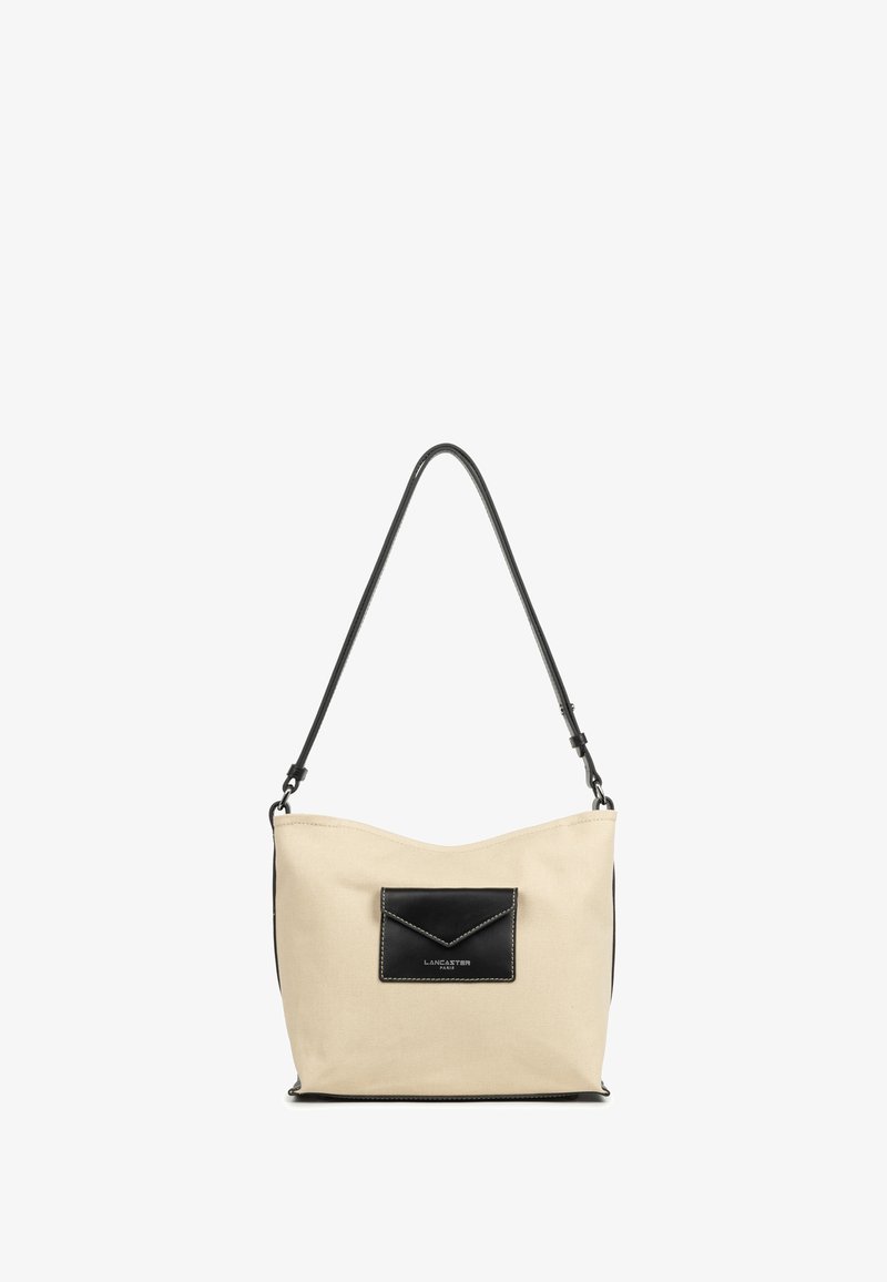 Borsa a spalla in canvas beige con tasca in pelle nera, forma arrotondata e una sola tracolla regolabile. Presenti dettagli di cucitura a contrasto.